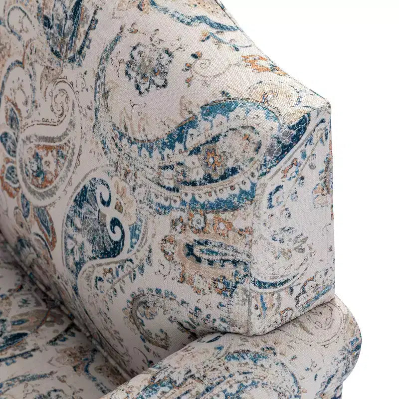 Fauteuil rembourré en bois avec motif floral, accoudoirs à panneaux et dossier en forme de bosse de chameau.